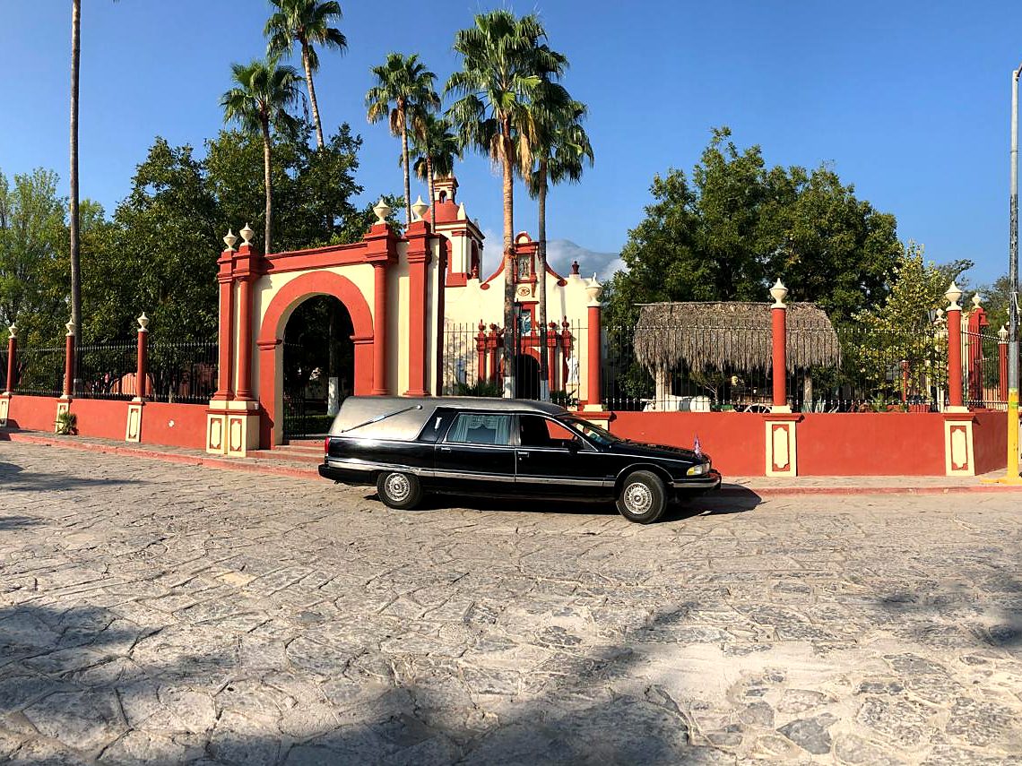 Carroza clásica negra restaurada frente a una iglesia