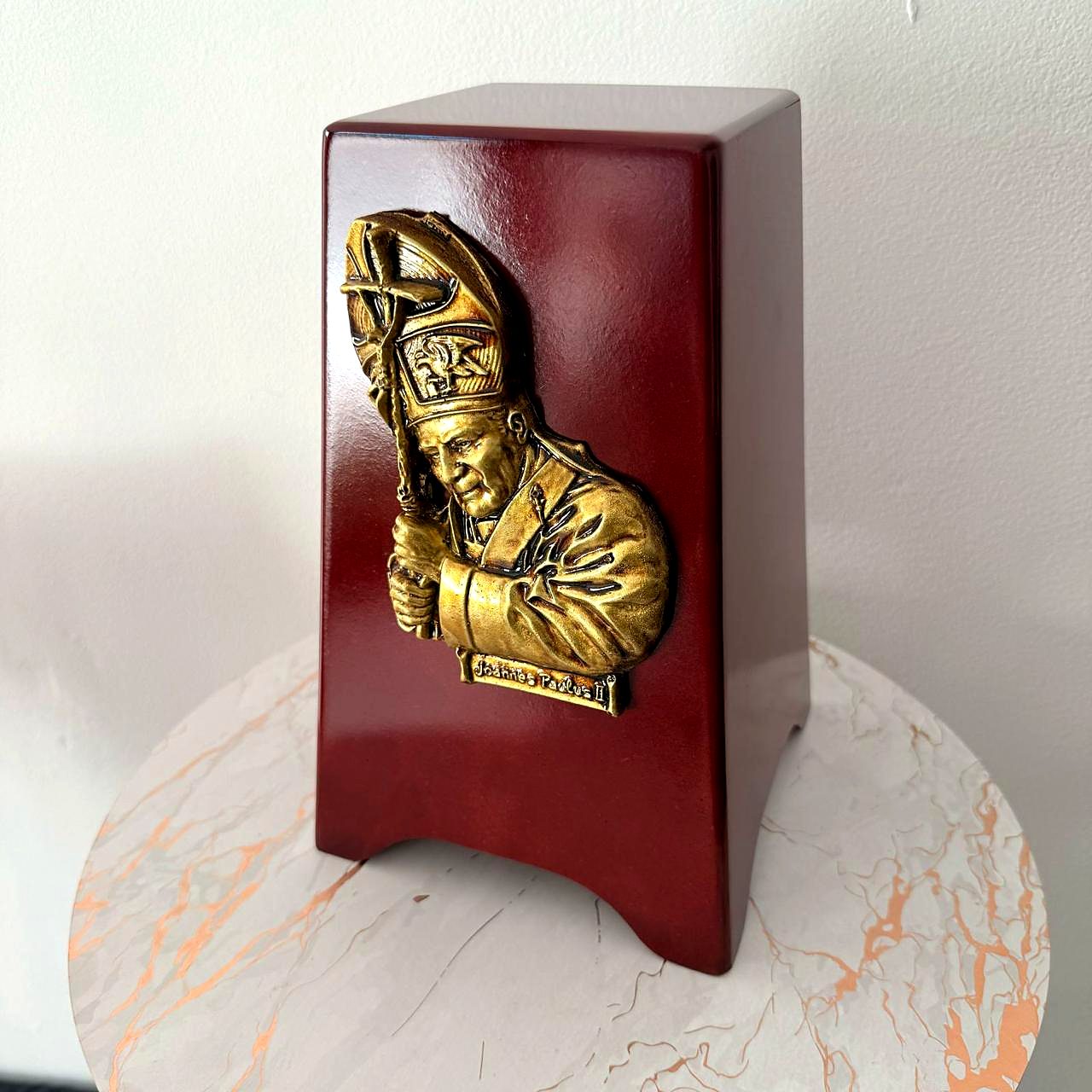 Urna color vino con San Juan Pablo II en relieve