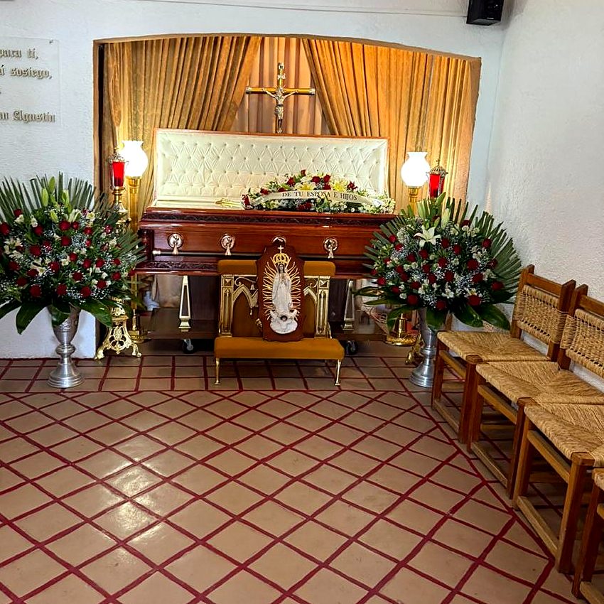 Sala de velación con arreglos de rosas y la Virgen de Guadalupe